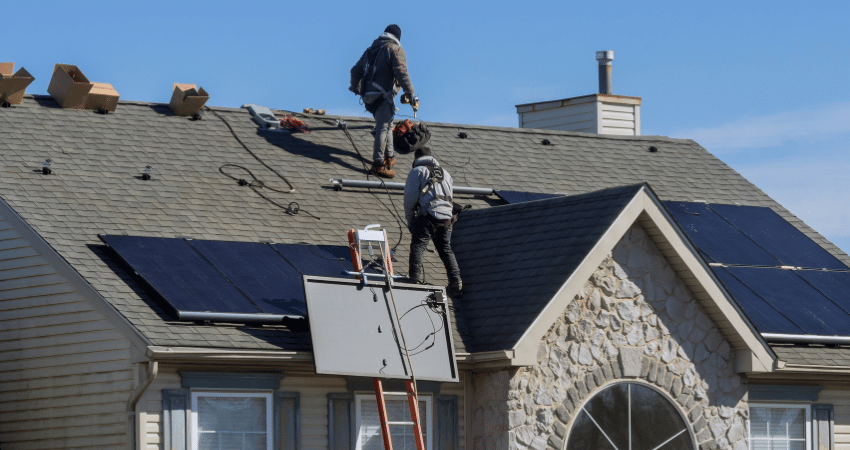 Roofers on roof with solar panels